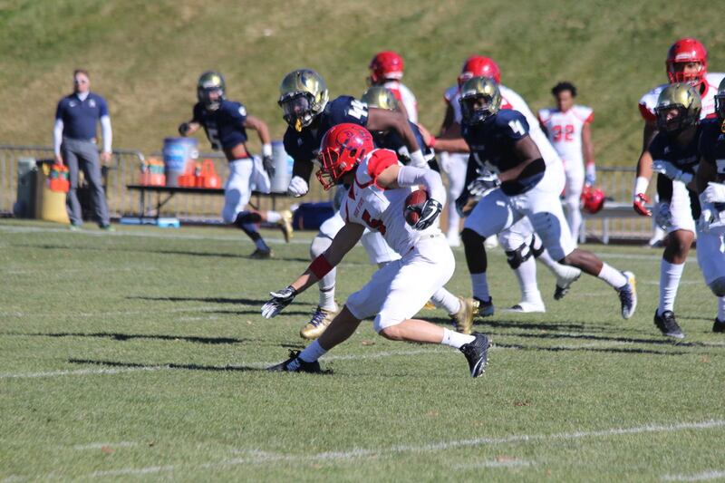 Dixie State quarterback Blake Barney (center) jukes a defender during a run against Fort Lewis on Saturday. Barney rushed for two touchdowns and threw for another in DSU's 23-13 win.
