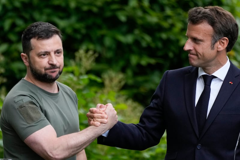 Ukraine President Volodymyr Zelenskyy, left, and France’s President Emmanuel Macron shake hands in 2022.