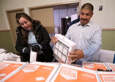 Charlotte Garcia and her fiancé, Ernie Luna, unwrap mattress covers at the Rescue Mission of Salt Lake on World Homeless Day in Salt Lake City on Wednesday, Oct. 10, 2018. Luna is a graduate of the mission's recovery program. Leesa Sleeps donated 150 matt