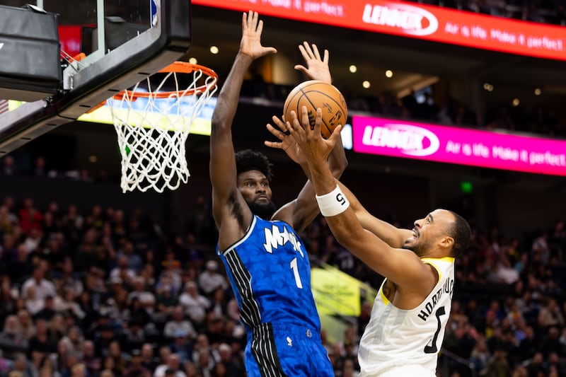 Utah Jazz guard Talen Horton-Tucker (wearing white) shoots the ball over Orlando Magic forward Jonathan Isaac