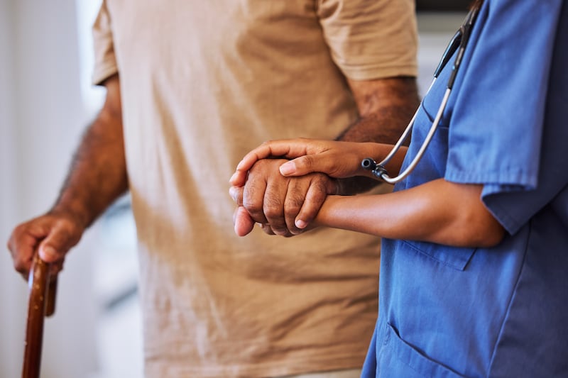 A nurse helps a patient walk.
