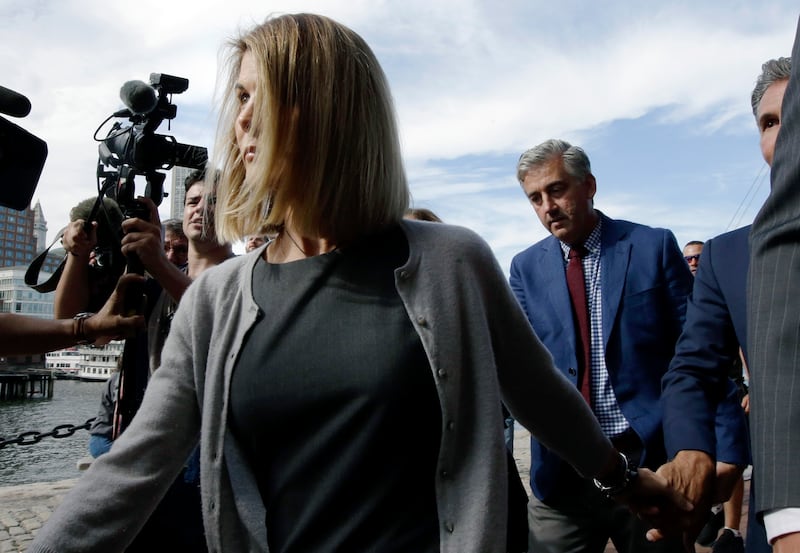 Lori Loughlin departs federal court Tuesday, Aug. 27, 2019, in Boston, after a hearing in a nationwide college admissions bribery scandal. At far right is her husband, clothing designer Mossimo Giannulli. (AP Photo/Steven Senne)
