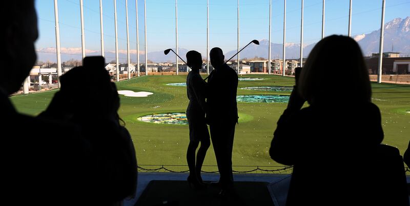 A couple pose for photos after getting married at Topgolf in Midvale on Tuesday, Feb. 14, 2017.