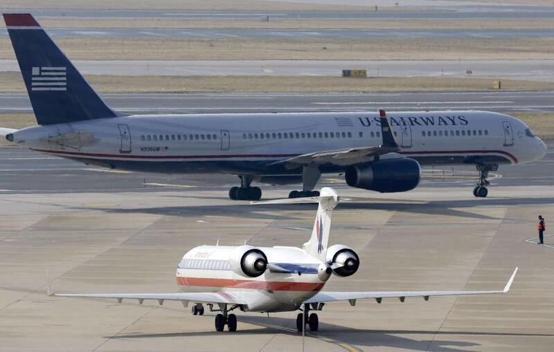 An American Airlines jet taxis near a US Airways plane at the Philadelphia International Airport in February.