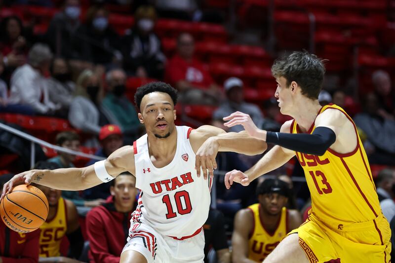 Utah Utes guard Marco Anthony (wearing white) drives against USC Trojans guard Drew Peterson