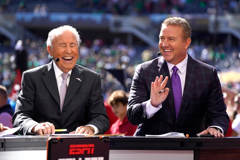 Kirk Herbstreit, right, shares a laugh with Lee Corso on set of ESPN’s “College GameDay” program in Soldier Field, Sept. 25.