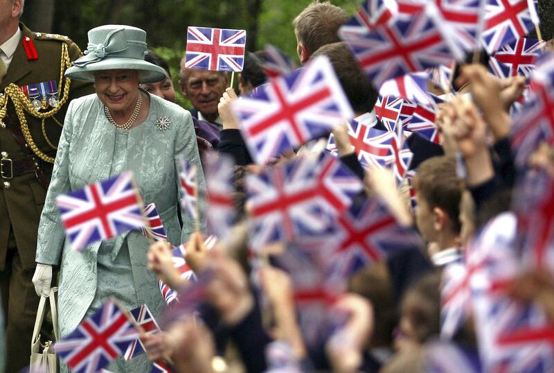 FILE - In this May 16, 2008 file photo, Britain's Queen Elizabeth II, left, is welcomed by children waving Britain's flag, upon her arrival at the British Embassy in Ankara, Turkey. Encouraged by the largely successful peace process in Northern Ireland, w