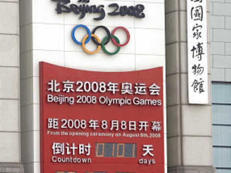 Chinese paramilitary officers clean an Olympic Games countdown clock near Tiananmen Square in Beijing Tuesday. The flame arrives in Hong Kong today.
