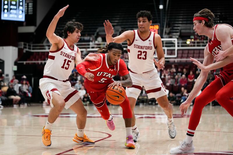 Utah guard Deivon Smith (5) dribbles between Stanford guard Benny Gealer (15) and forward Brandon Angel (23) during the first half of an NCAA college basketball game, Sunday, Jan. 14, 2024, in Stanford, Calif.
