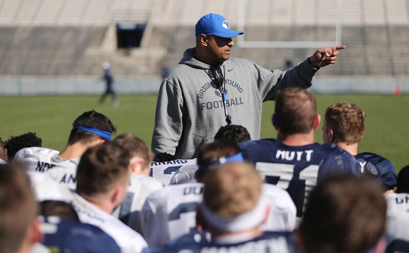 Brigham Young Cougars head coach Kalani Sitake talks with players in Provo Friday, April 1, 2016.
