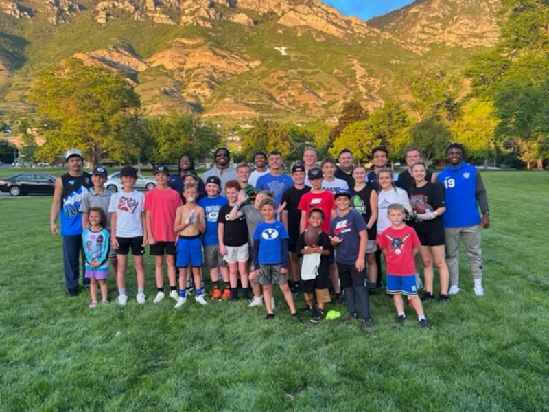 Jake Brandon, fourth from right on back row, co-founder of CougConnect, poses with young fans at a CougConnect event.