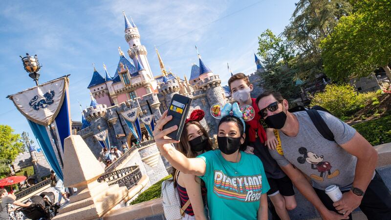 A family outside of Sleeping Beauty Castle at Disneyland Park in Anaheim, California.