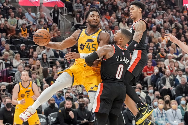 Utah Jazz guard Donovan Mitchell (45) passes as Portland Trail Blazers’ Damian Lillard (0) and guard Anfernee Simons