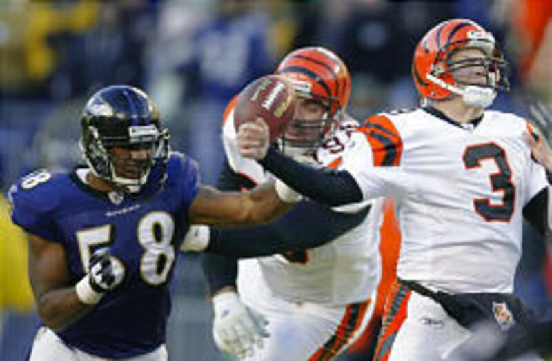 Raven linebacker Peter Boulware, left, gets by Scott Rehberg and hits the arm of Bengal QB Jon Kitna.