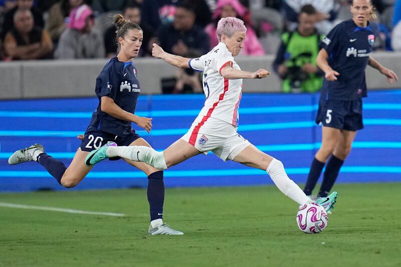 OL Reign forward Megan Rapinoe, center, passes the ball as San Diego Wave defender Christen Westphal defends during an NWSL semifinal match on Nov. 5, 2023.
