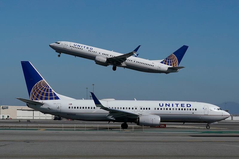 In this Oct. 15, 2020, file photo, a United Airlines airplane takes off over a plane on the runway at San Francisco International Airport in San Francisco.