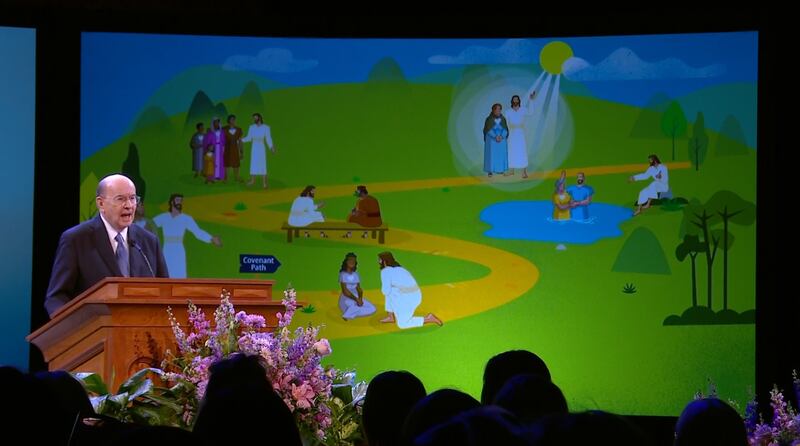 Elder Quentin L. Cook speaks in front of an illustration of the covenant path at the 2025 BYU Women's Conference.