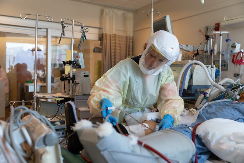 Healthcare workers care for a COVID-19 patient in the ICU at Intermountain Medical Center in Murray.