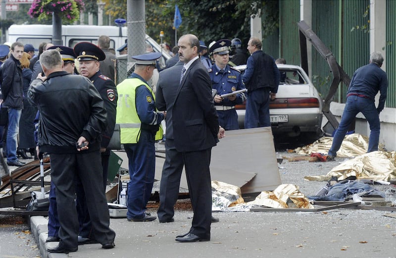 In this photo made Saturday, Sept. 22, 2012, law enforcement authorities work at the site of the crash where a heavily drunk driver killed seven people at a bus stop in Moscow, Russia. Five orphaned teens were waiting for a bus with their guardians in Mo