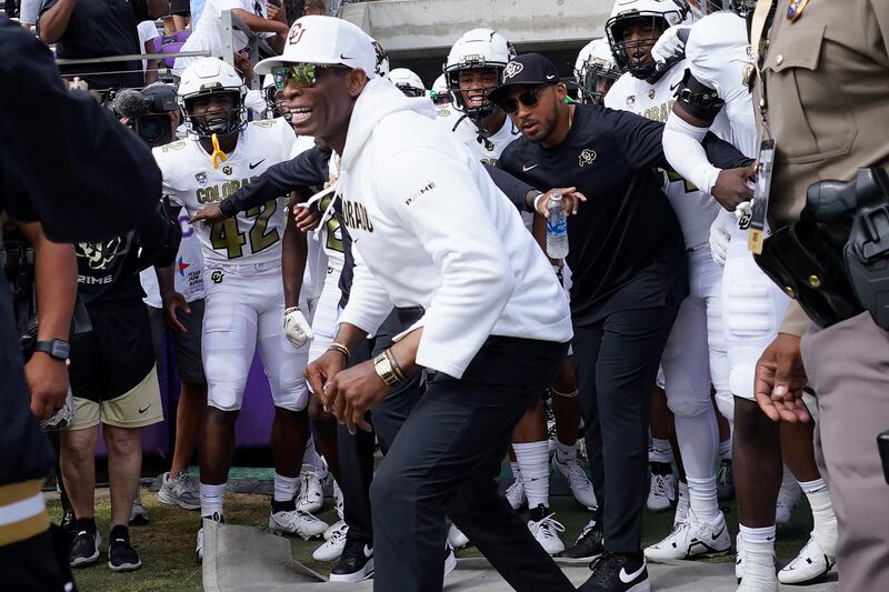 Colorado head coach Deion Sanders runs onto the field with his team for an NCAA college football game against TCU.