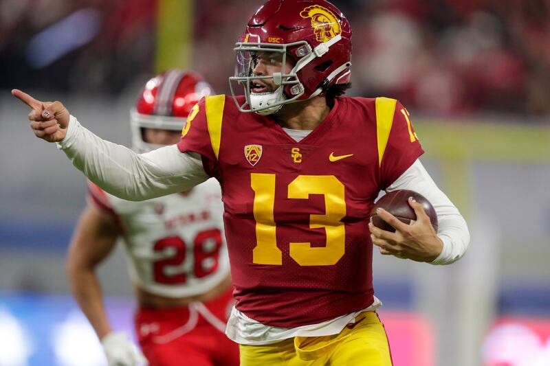 USC QB Caleb Williams points while he runs the ball for a first down during Pac-12 championship game against the Utes.