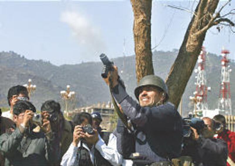 A Pakistani police officer fires a tear gas shell to disperse protesters during a demonstration in Islamabad Friday.