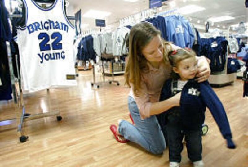 Julie Dixson helps her daughter, Kylie, 2, try on a BYU sweatshirt at the school's bookstore on the Provo campus.