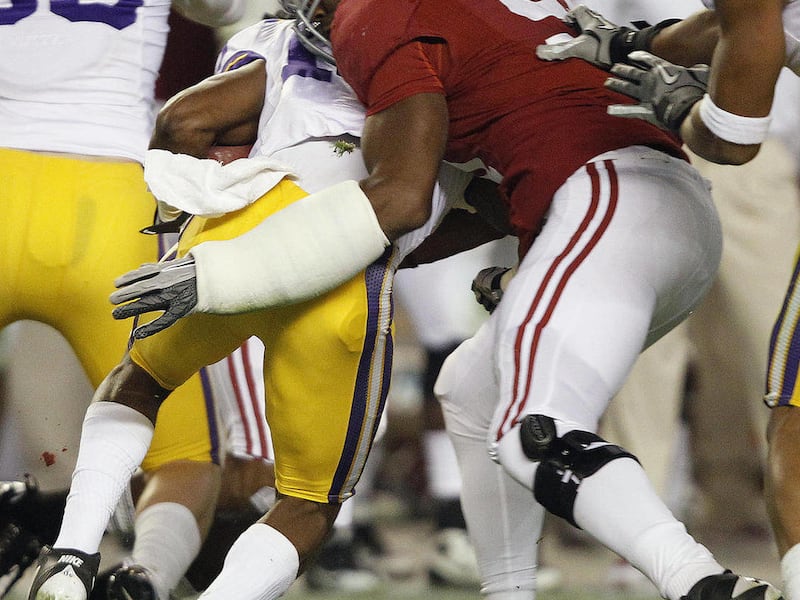 In this Saturday, Nov. 5, 2011 photo, Alabama's Alex Watkins (91) tackles LSU's Ron Brooks during the second half of an NCAA college football game, in Tuscaloosa, Ala. Watkins grew up chopping wood for his grandmother's old stove in rural Tennessee. Maybe
