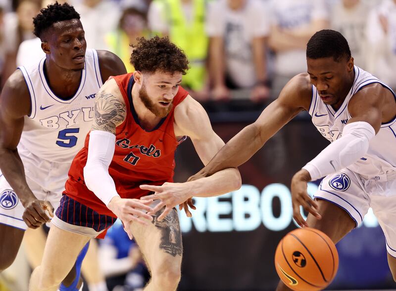 Saint Mary’s guard Logan Johnson (0) and BYU guards Rudi Williams (3) and Gideon George defend during game in Provo.