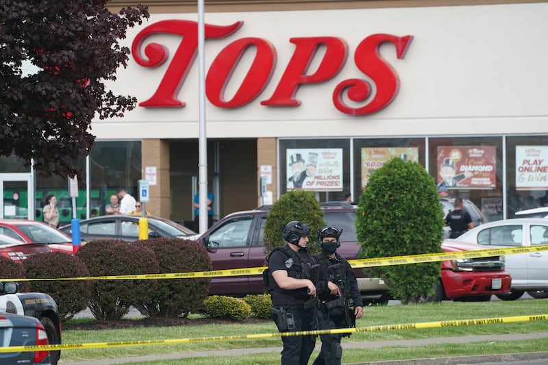 Police secure an area around a supermarket where several people were killed in a shooting, Saturday, May 14, 2022 in Buffalo, N.Y. Officials said the gunman entered the supermarket with a rifle and opened fire. Investigators believe the man may have been livestreaming the shooting and were looking into whether he had posted a manifesto online.
