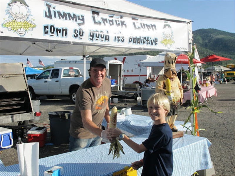 Max Strong enjoys an ear of roasted corn at Jason Lively's "Jimmy Crack Corn" stand at the Park City farmers market.