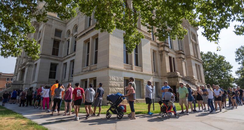 A long line of voters wraps around the Sedgwick County Historic Courthouse in Wichita, Kan., on Monday, Aug. 1, 2022.