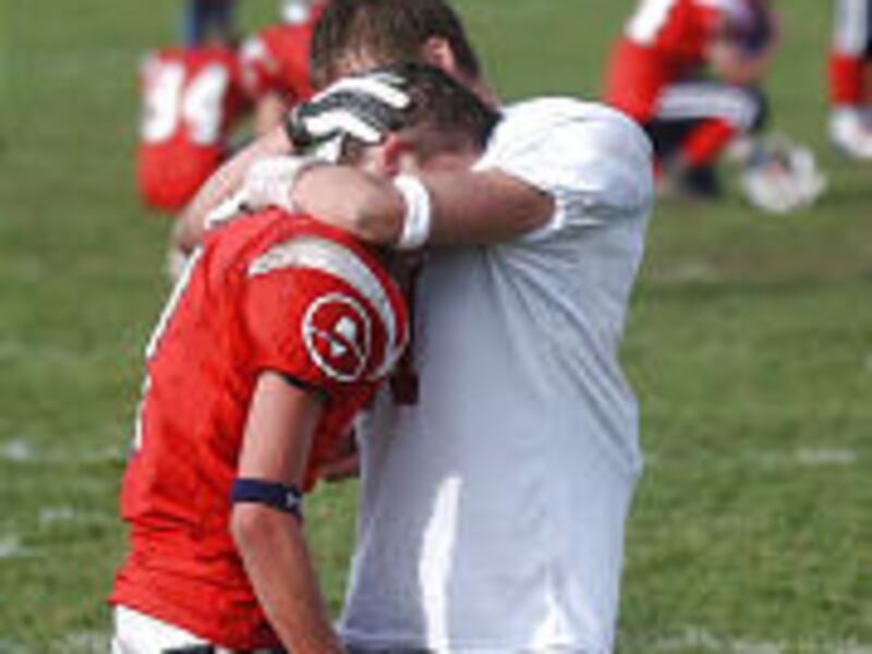 Springville's Tanner Rehrer, left, is consoled by Logan's Roger Ellis after last week's double-overtime Grizzlies' upset of the Red Devils in the opening round of the state 4A football playoffs.