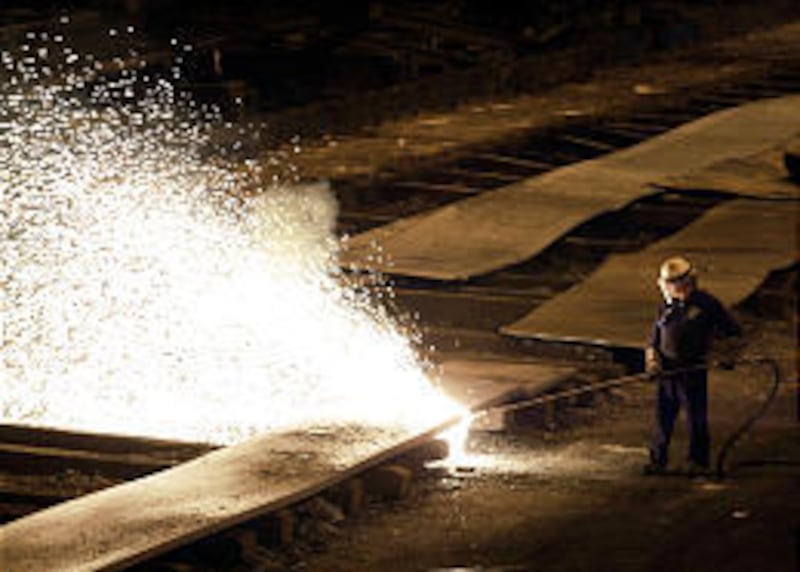 A worker cuts up slabs of steel at the International Steel Group Inc. plant in Cleveland, Ohio, in July.