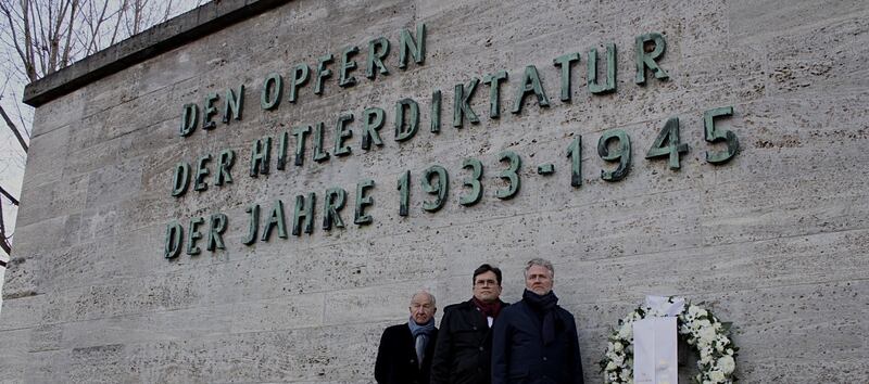Hartmut Woite, Ralf Grünke and Daniel Fingerle standing in front of the Gedenkstätte Plötzensee Memorial Wall in Berlin, Germany.
