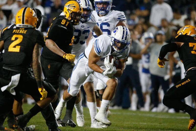 Brigham Young running back Lopini Katoa, center, runs under pressure during game against Arizona State in Provo.