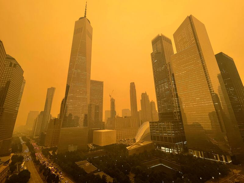 Traffic moves along West Street past One World Trade Center in New York amid smoky haze from wildfires in Canada.