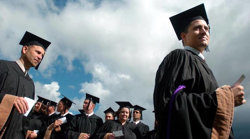 MBA graduates file forward to receive their diplomas during commencement exercises.