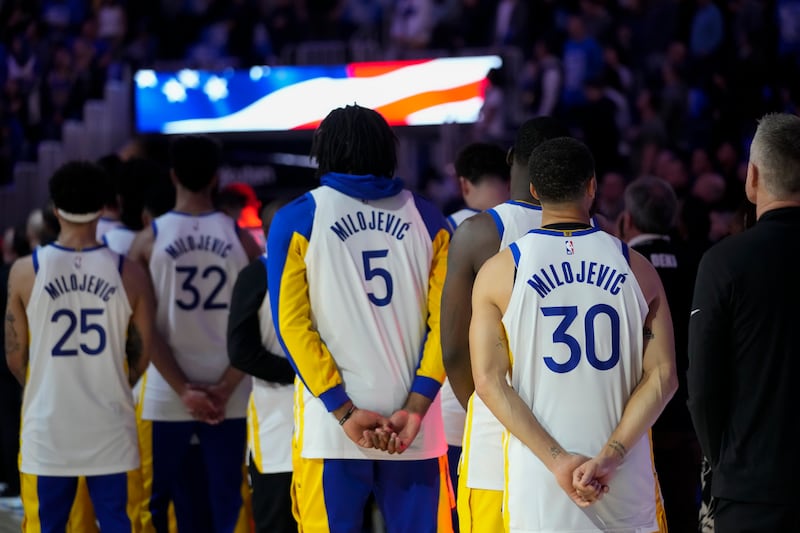The Golden State Warriors listen to the national anthem before a game against the Atlanta Hawks, Jan. 24, 2024, in San Francisco.
