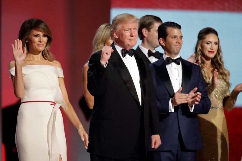 FILE - In this Jan. 20, 2017, file photo President Donald Trump, center, raises his fist alongside first lady Melania Trump, left, and son Donald Trump, Jr., after dancing at the Liberty Ball following his inauguration in Washington. Federal prosecutors a