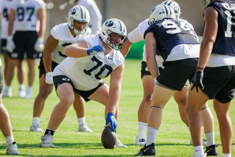 BYU center Connor Pay prepares to snap the ball during fall camp in Provo on Aug. 1, 2024.