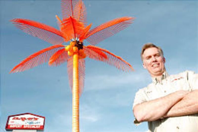 Dave Bell, owner of Dave's Complete Auto Care in Centerville, with a fake palm tree.