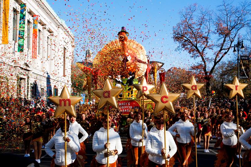Performers walk in front of Macy’s Tom Turkey float as they take part in the 92nd annual Macy’s Thanksgiving Day Parade in New York.