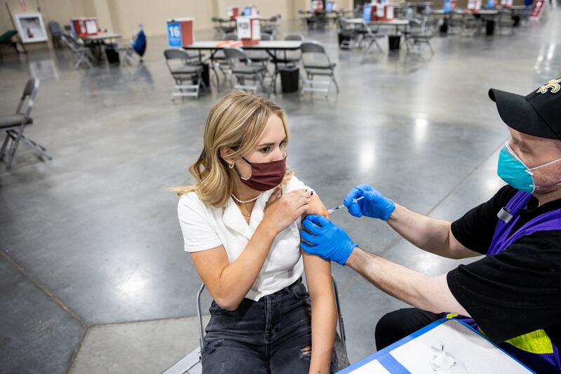 Sofia Carlson gets her first dose of the COVID-19 vaccine from nurse Travis Langston at the Mountain America Expo Center in Sandy.