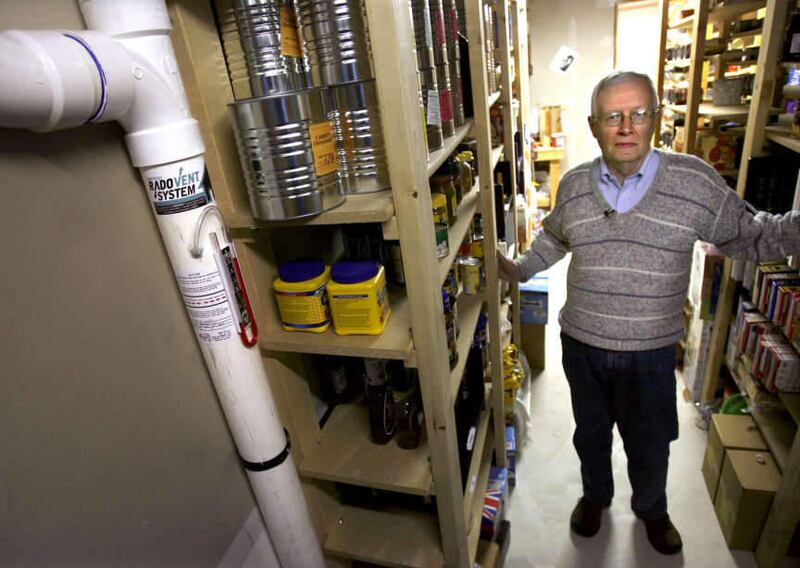 In a basement stocked with emergency food supplies Charlie McQuinn, 71, shows the radon mitigation system in his Cottonwood Heights home on Thursday, December 1, 2011.