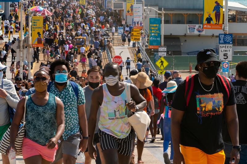 People crowd the Santa Monica Pier in Santa Monica, Calif.