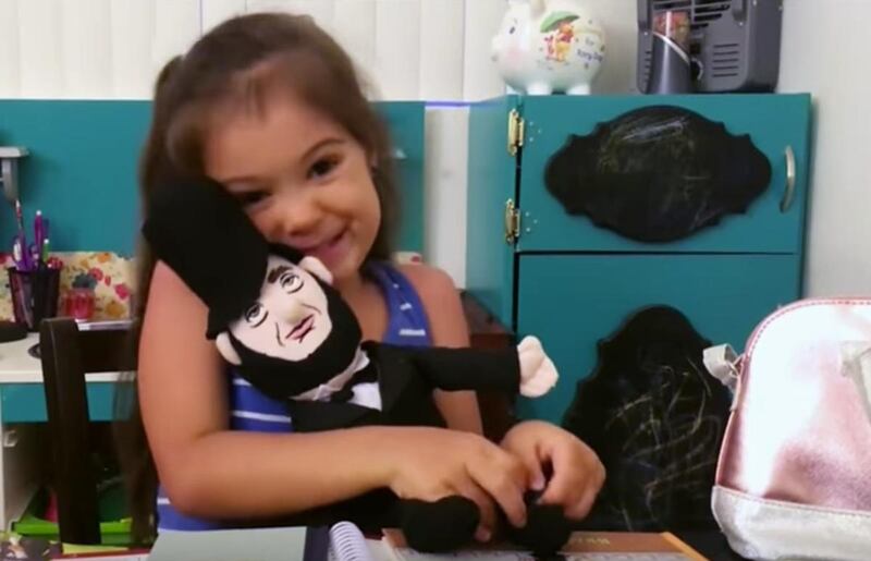 5-year-old Lucy snuggles her stuffed Abraham Lincoln doll.