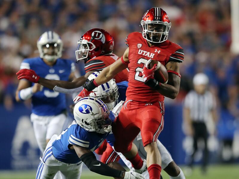 Brigham Young Cougars defensive back Isaiah Herron brings down Utah Utes running back Micah Bernard.
