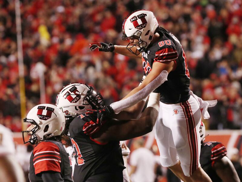Utah tight end Brant Kuithe celebrates a TD with offensive lineman Bamidele Olaseni in Salt Lake City on Oct. 16, 2021.