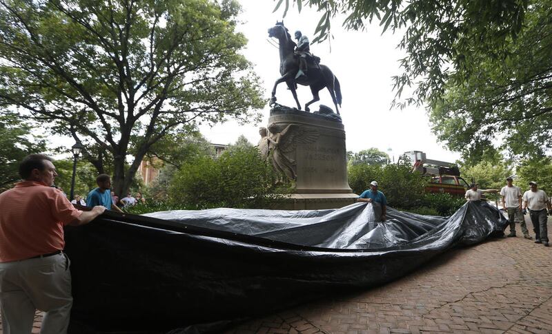 City workers prepare to drape a tarp over the statue of Confederate General Stonewall Jackson in Justice park in Charlottesville, Va., Wednesday, Aug. 23, 2017.